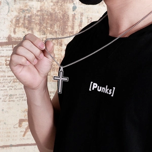 Men's silver cross necklace with black inlay on a vintage background shown by a model