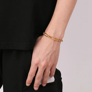 Detail of a gold stainless steel link chain bracelet worn on a wrist for men and women