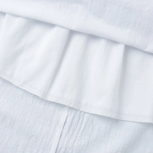 Detail view of cotton dress fabric showing fine stitching and multi-layered white texture