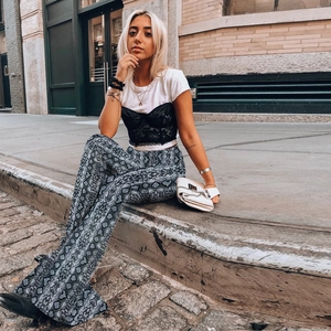 Street style shot of high-waisted wide-leg trousers featuring a grey snakeskin pattern