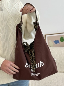 Brown nylon tote bag with leopard print lining and Bonjour print shown on a model