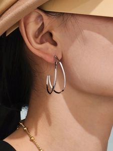 Gros plan de boucles d'oreilles minimalistes argentées double couche portées par un mannequin
