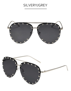 Close-up of pilot sunglasses with silver metal frame, grey lenses and silver rivet details