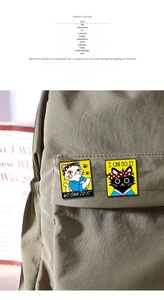 Detail of creative cat enamel pins with motivational gestures on a khaki canvas bag