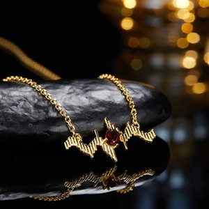 S925 silver necklace with pulse wave design and red gemstone on dark stones