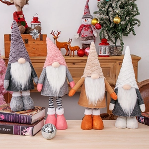Set of four plush Christmas gnomes in various colors on a festive wooden tabletop