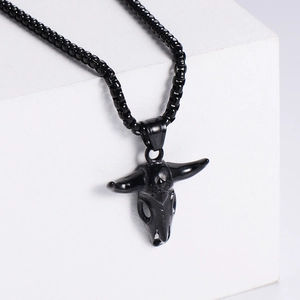 Gothic black bull skull pendant necklace in stainless steel on a white geometric stand