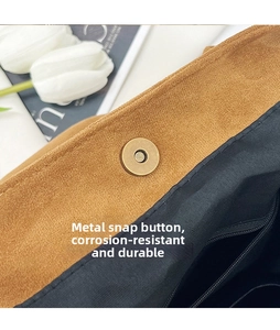 Detailed view of brown suede tote bag with durable magnetic clasp and black lining