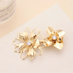 Macro shot of gold floral hair clip with hollow petals and crystal centerpiece