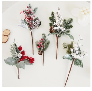 Detailed view of Christmas branches with pine cones, red berries and artificial snow effect