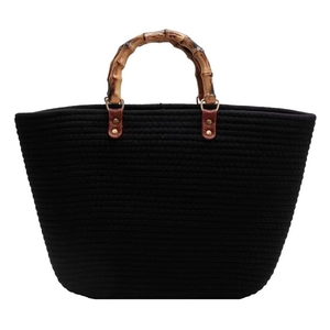 Black woven cotton tote bag with bamboo top handles and premium leather stitching detail