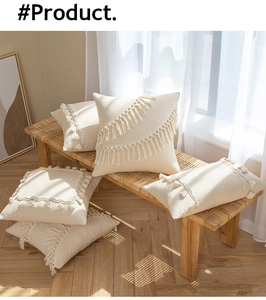 Detail of cream boho cushion cover showing tufted texture and tassel fringe accents