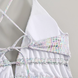 Close-up detail of white bikini top featuring holographic grid trim and thin cross straps