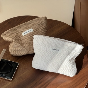 Textured woven cosmetic bags in khaki and white with a simple wish minimalist label