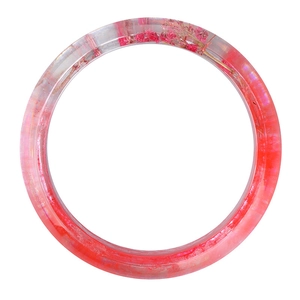 Dettaglio di un bracciale in resina trasparente con fiori secchi rosa incorporati all'interno