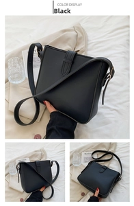 Detail of minimalist black leather bucket bag with adjustable strap and side view highlights