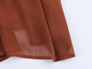 Detailaufnahme von fließendem karamellfarbenem Chiffon mit Saumnaht und Textur