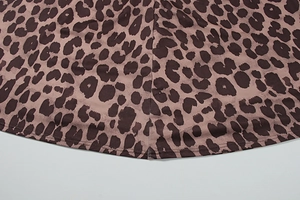 Detailed close-up of double-stitched hem and stitching on leopard print fabric