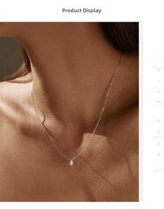 Gros plan d'un pendentif en moissanite en forme de poire sur une fine chaîne en argent