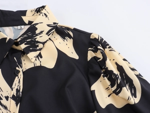 Detailed view of puff sleeves and turn-down collar on a black printed shirt dress