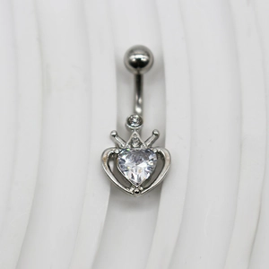 Détail d'un piercing de nombril en argent avec motif cœur couronne et cristaux clairs