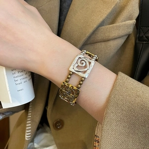 Detailed close-up of retro double-layer beaded bracelet with gold and silver square charms