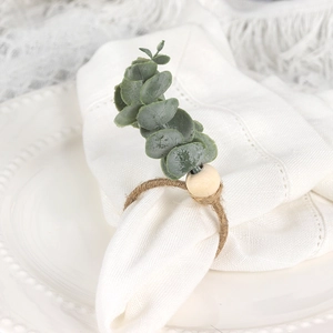 Detail of eucalyptus leaf napkin ring with natural wood bead and rustic twine wrap