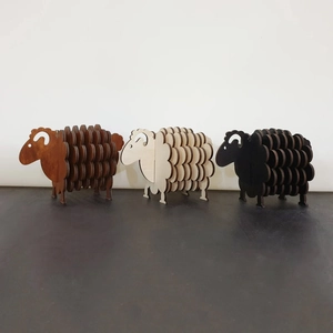 Three-piece set of wooden sheep coasters in brown, off-white, and black minimalist style