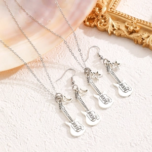 Dettaglio del set collana con ciondolo a chitarra d'argento e orecchini stella e luna