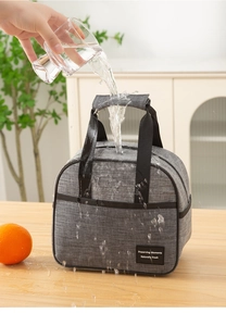 Detailed view of the water-resistant gray fabric and durable handle of the lunch bag