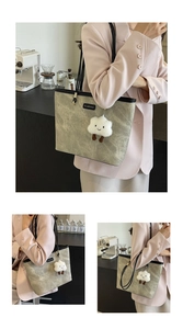 Detail of a beige tote bag with black trim and a white cloud plush charm in a cafe