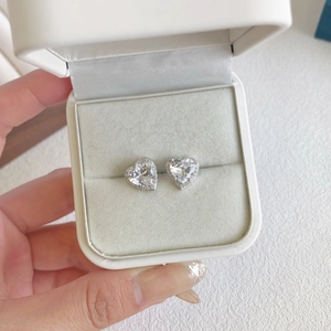 Macro shot of silver S925 heart earrings with 5A zircon in a white gift box