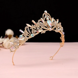 Detailed macro view of baroque gold tiara with intricate floral patterns and white crystals