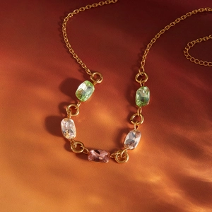 Dettaglio della collana in titanio dorato con strass ovali colorati ed eleganti giochi di luce