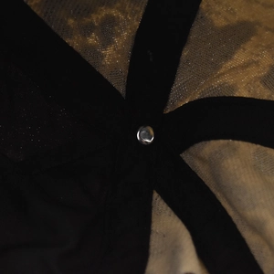 Macro detail of cotton leopard baseball cap interior with reinforced webbing and metal rivet