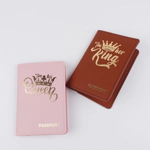 Detail of pink and brown leather passport covers with King and Queen gold stampings
