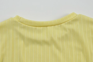Détail macro de la texture du tricot côtelé jaune citron et encolure ronde de qualité