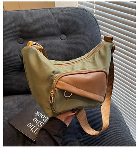 Detail of olive green nylon hobo bag with brown leather triangle pocket and gold hardware