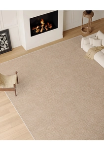 Top-down view of a beige woven rug showing detailed texture and white borders on wood floor