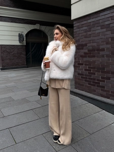 Three-piece women's knit set with white faux fur jacket and beige wide-leg trousers