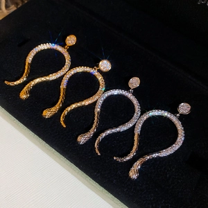 Detailed view of 14k gold and silver plated snake earrings with shimmering cubic zirconia