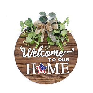 Panneau de bienvenue en bois avec feuilles d'eucalyptus et nœud en toile sur fond blanc