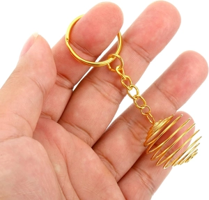 Detailed view of a golden spiral cage pendant keychain for DIY jewelry and beads