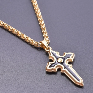 Macro detail of gothic gold and black enamel cross pendant with textured wheat chain