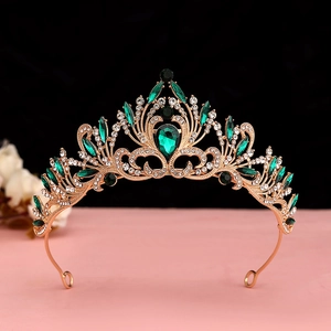 Macro detail of gold tiara featuring emerald green crystals and sparkling rhinestones