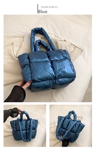 Detail of blue quilted puffer tote bag showing metallic finish and soft padded fabric