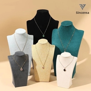 Detailed display of necklaces on various velvet and fabric portrait bust jewelry stands