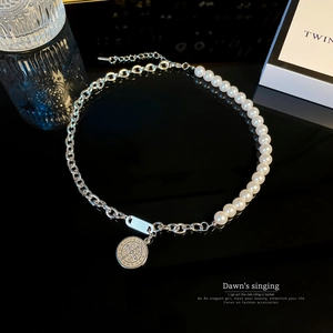 Minimalist silver chain and pearl necklace with vintage coin pendant on black background
