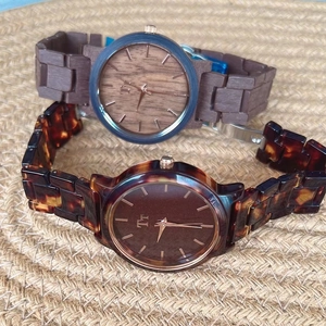 Detail view of two vintage tortoiseshell watches with wood grain and glitter dials on mat