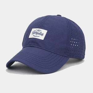 Detail of navy quick-dry baseball cap with laser-cut side vents and paradise patch